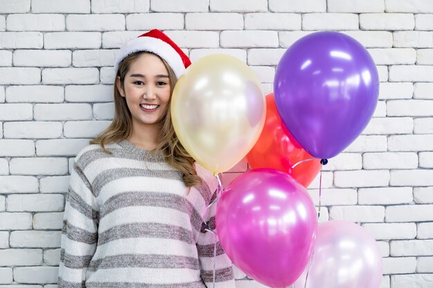 Junge Frau im Kostüm Weihnachten auf weißem Backsteinhintergrund.