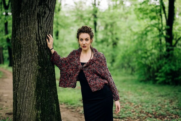 Junge Frau im Park durch Baum