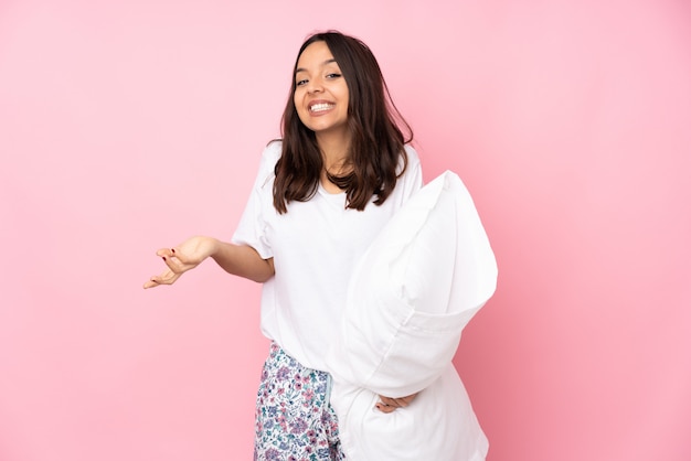 Junge Frau im Pyjama auf rosa Wand lächelnd