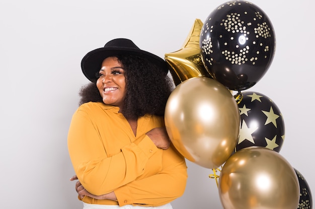 Junge Frau im stilvollen Outfit mit Luftballons