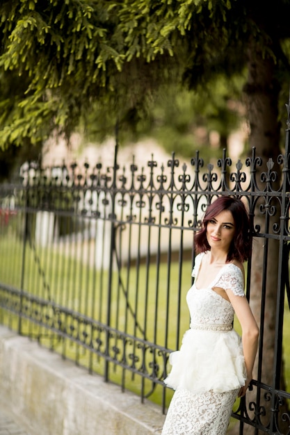 Junge Frau im weißen dress durch den Zaun