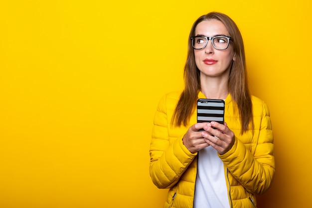 Junge Frau in Brille und gelber Jacke