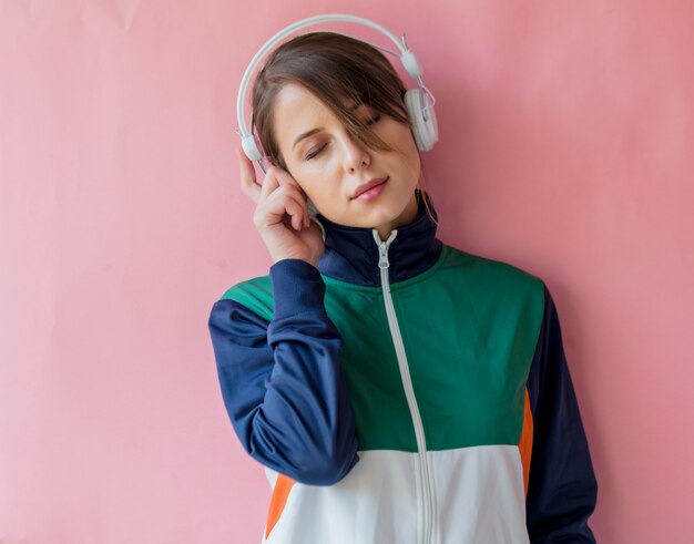 Junge Frau in der Art 90s kleidet mit Kopfhörern