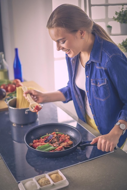 Junge Frau in der Küche, die ein Essen zubereitet