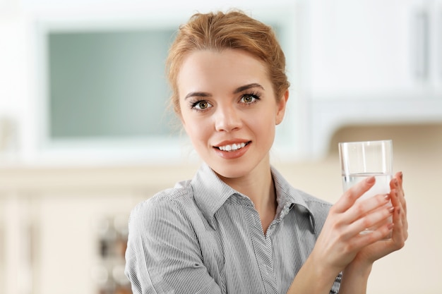 Junge Frau in der Küche Trinkwasser