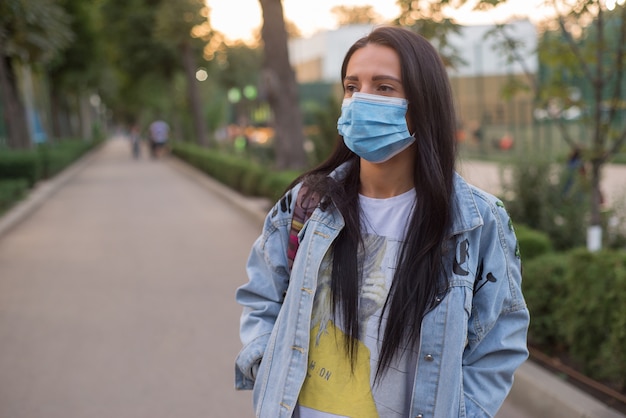 junge Frau in der medizinischen Maske im Freien