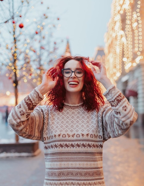 Junge Frau in der Pulloverweihnachtsstadt