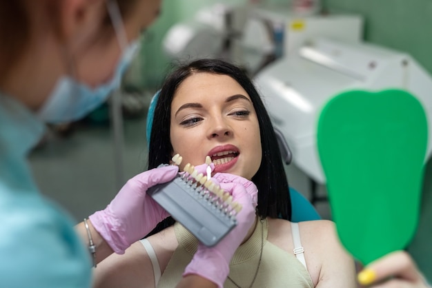 Junge Frau in der Zahnmedizin mit Arzt im Gespräch über Zahnhygiene