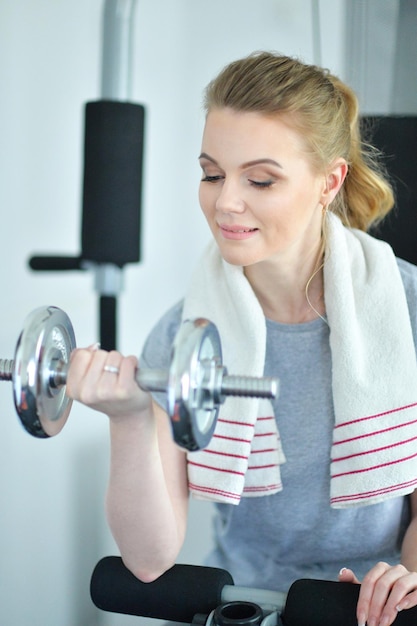 Junge Frau in einem Fitnessstudio mit einer Hantel