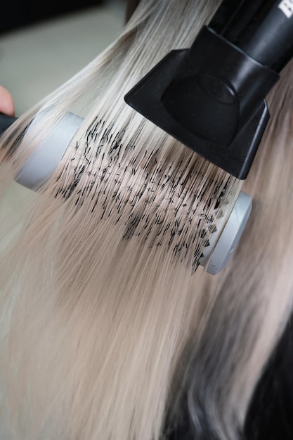 Junge Frau in einem Friseursalon färbt ihr Haar blond und trocknet Haare