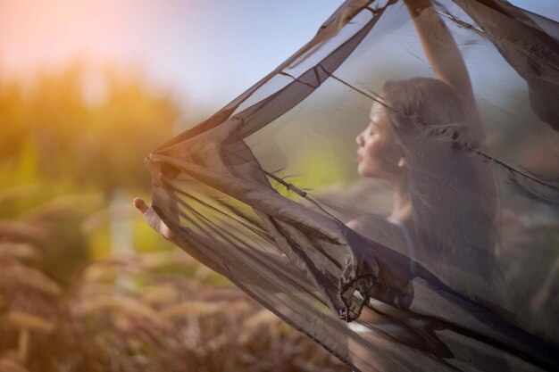 Junge Frau in einem hellen Badeanzug ruht glücklich in einem Sommerurlaub in der Abendsonne.