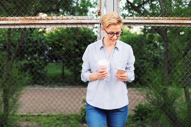 Junge Frau in einem Hemd, das eine Kaffeetasse hält