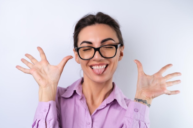 Junge Frau in einem lila Hemd auf weißem Hintergrund mit Brille für das Sehen fröhlich positiv in guter Laune