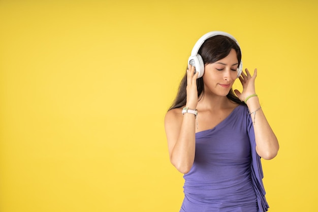 Junge Frau in einem lila T-Shirt konzentriert sich auf das Hören von Musik