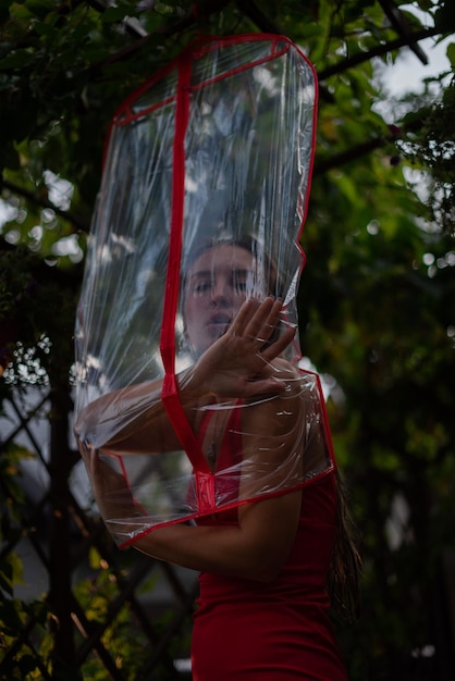 Junge Frau in einem roten Kleid, gekleidet in einer Tasche für Kleidung