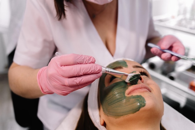 Junge Frau in einem Spa mit Algen-Gesichtsmaske Frau im Spa-Salon