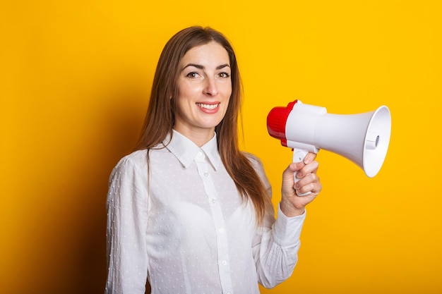 Junge Frau in einem weißen Hemd hält ein Megaphon in ihren Händen auf gelbem Hintergrund Hilfe beim Einstellungskonzept wollte Banner