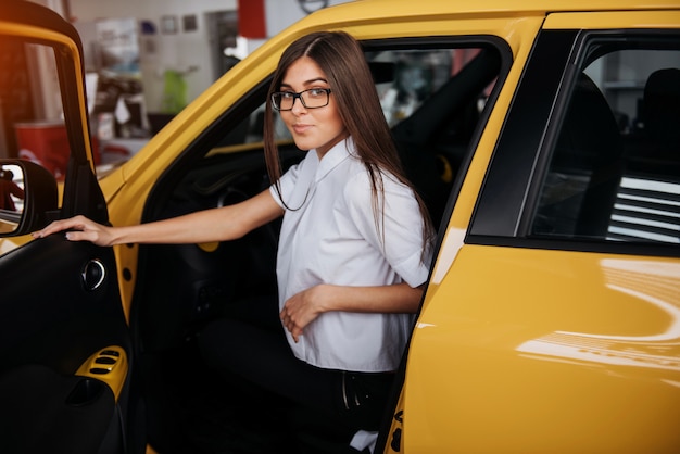 Junge Frau in ihrem neuen Auto lächelnd