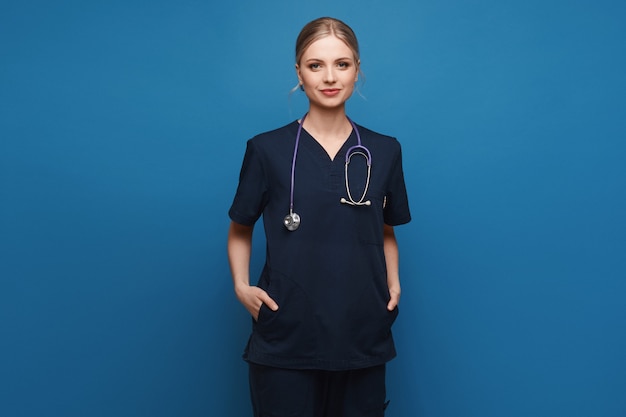 Junge Frau in medizinischer Uniform und mit Stethoskopaufstellung