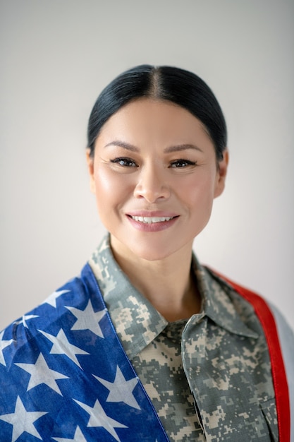 Junge Frau in Militäruniform mit der amerikanischen Flagge