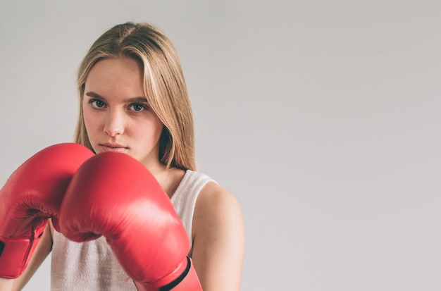 Junge Frau in roten Boxhandschuhen