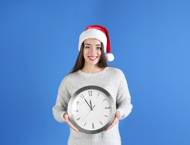 Junge Frau in Sankt-Hut mit Uhr. Weihnachts-Countdown-Konzept