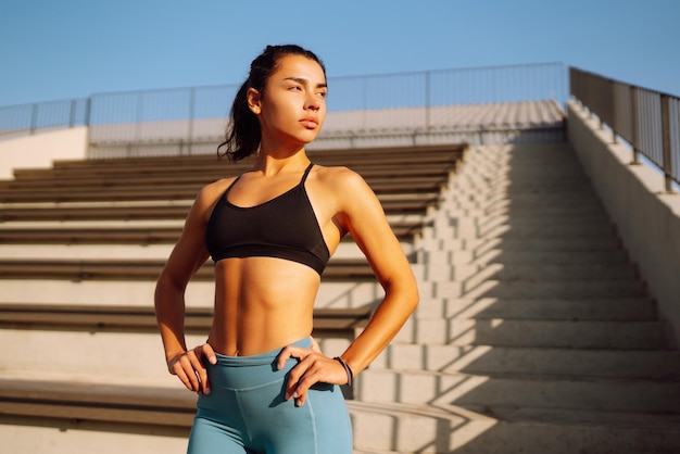 Junge Frau in Sportkleidung, die morgens im Freien trainiert, Frau, die sich dehnt