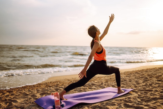 Junge Frau in Sportkleidung macht Yoga-Fitness-Übungen am Strand Sport Aktives Leben