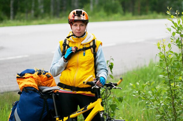 Junge Frau in sportlicher Kleidung und Helm, die allein mit dem Fahrrad reisen