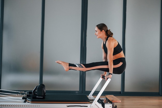 Junge Frau in sportlicher Kleidung und mit schlankem Körper haben Fitness-Yoga-Tag drinnen