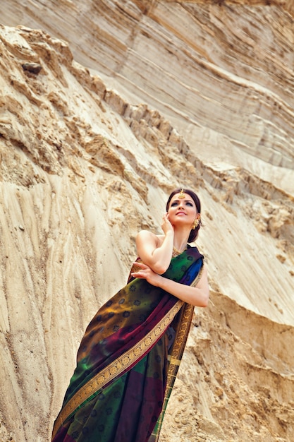 Junge Frau in traditioneller indischer Kleidung vor dem Sandhintergrund