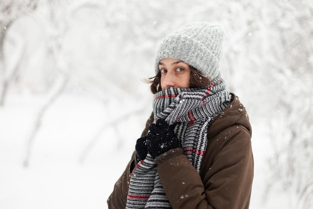 Junge Frau in warmer Kleidung bei verschneitem Winterwetter im Freien