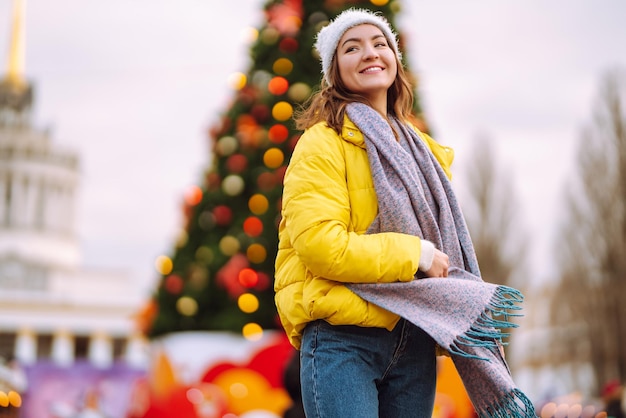 Junge Frau in warmer Winterkleidung, die beim Festival aufwirft. Winterferien.