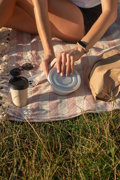 Junge Frau isst frischen Salat im Park auf dem Gras