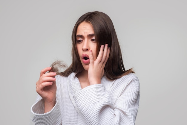 Junge Frau ist sehr verärgert wegen Haarausfall, Haarschnitt und gesunder Haarpflege, ernsthafter Haarausfall