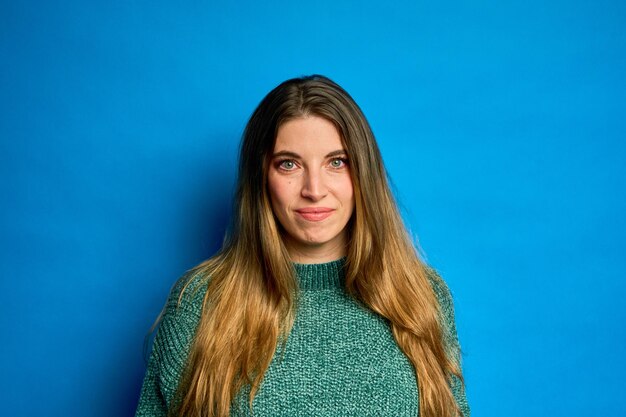 Junge Frau lächelt auf blauem Hintergrund Studio-Porträt