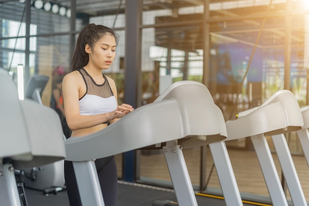Junge Frau läuft auf dem Laufband im Fitnessstudio