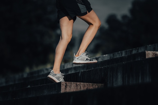 Junge Frau läuft im Sommer in der Stadt auf dem Morgenlauf Treppenhintergrund