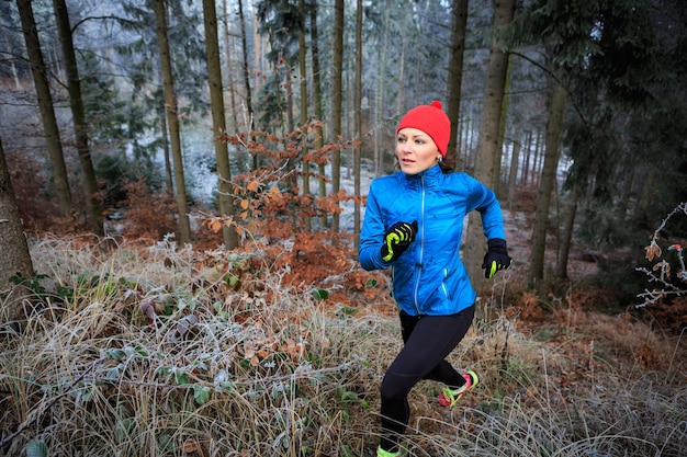 Junge Frau läuft im Winter im Wald