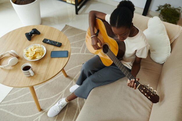 Junge Frau lernt Gitarre spielen