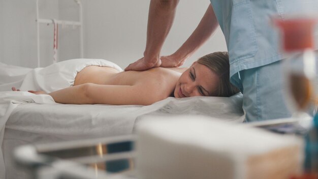 Junge Frau liegt auf einem Massagetisch - therapeutische manuelle Therapie, Medizin