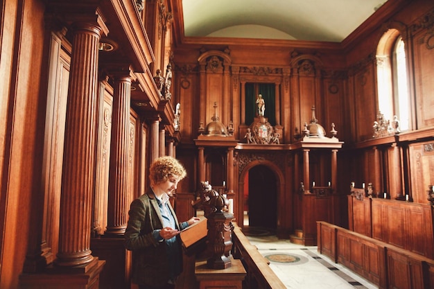 Junge Frau liest die Bibel, während sie in der Kirche steht