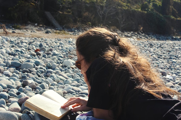 Junge Frau liest ein Buch am Strand Sonne und Sommerferien im Schwarzen Meer
