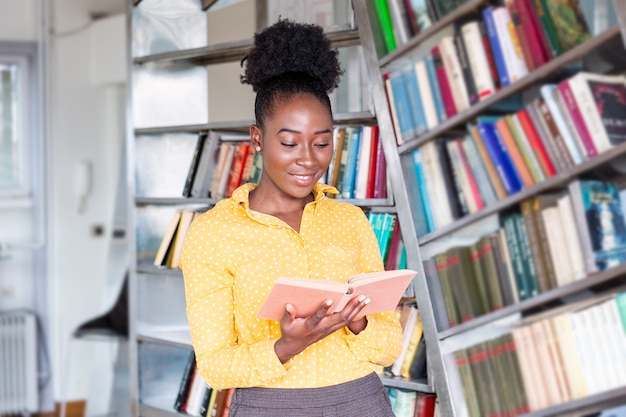 junge Frau liest ein Buch in der alten Bibliothek