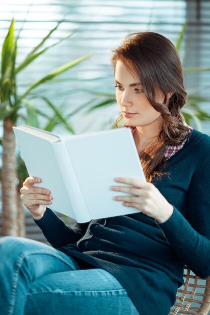 Junge Frau liest ein Buch mit leerem Einband