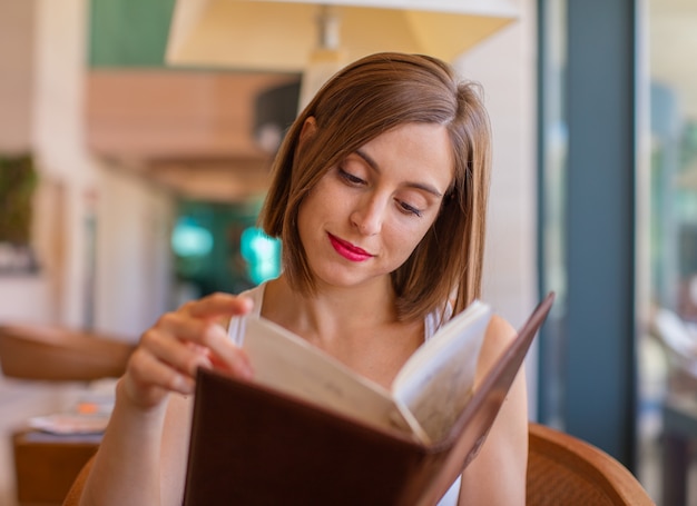 junge Frau liest in einem Resort