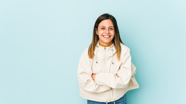 Junge Frau lokalisiert auf blauer Wand, die lacht und Spaß hat.