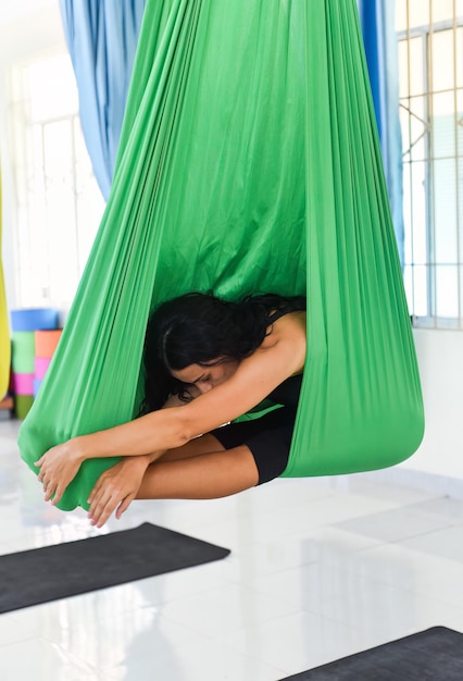 Foto junge frau macht eine luft- oder fliegen-yoga-pose