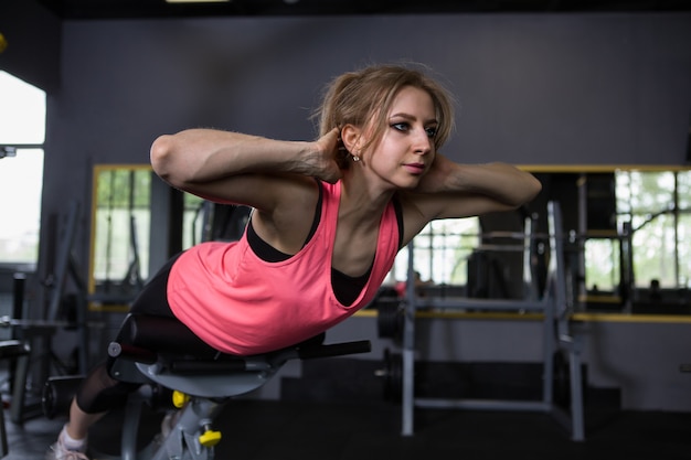 Junge Frau macht Hyperextensionsübung im Fitnessstudio