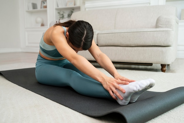 Junge Frau macht ihr Training auf einer Fitnessmatte